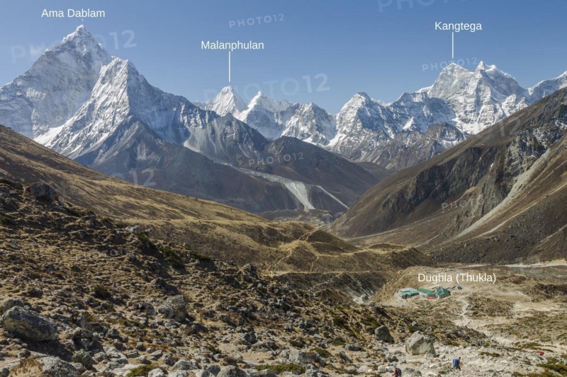 Looking back from the steep approach to Thokla on the Everest Base Camp trekking route. Dughla settlement is below, located on the way between Dingboche or Pheriche and Lobuche. It is Ama Dablam on the left-hand side, Kangtega on the right, and among other over 6000 m high peaks, Malanphulan draws the attention with its attractive, unclimbed north face. Photo with peak labels. Khumbu, the Everest Region, Himalayas. Sagarmatha National Park, a UNESCO World Heritage Site. Solukhumbu, Nepal, Asia