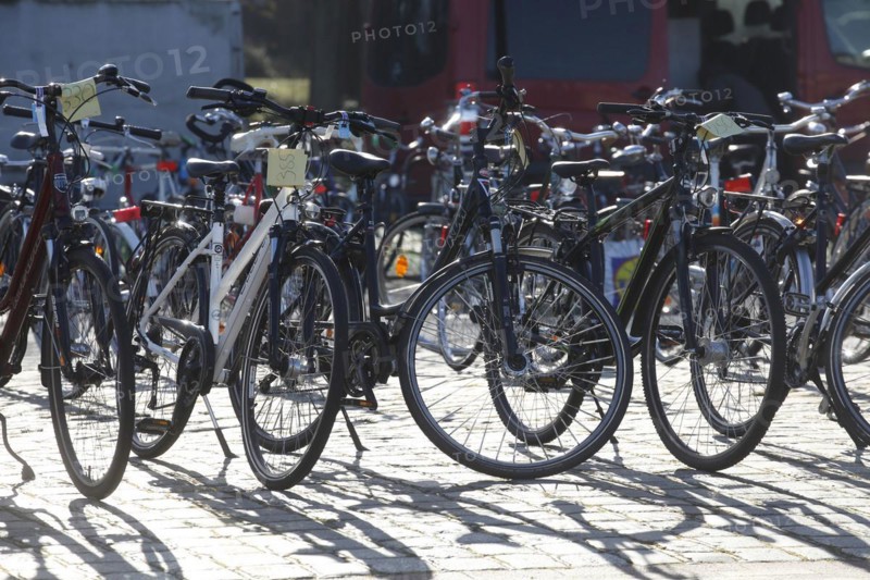 Parking bicycles backlit with price tags standing on the asphalt at a bicycle market, Germany, Europe