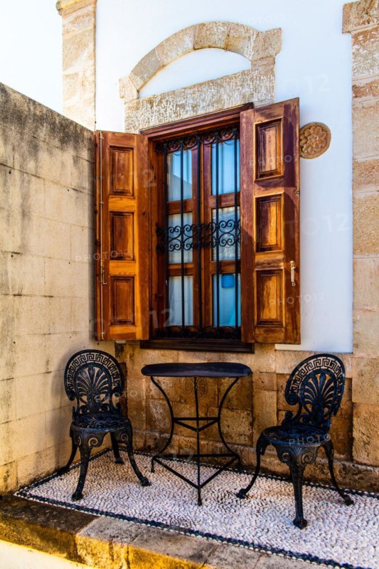 Sitting area with pebble mosaics on the floor, winding alleys with white houses, Lindos, Rhodes, Greece, Europe