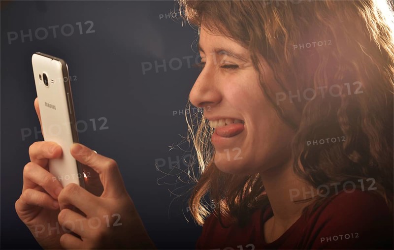 An 11-year-old girl stands as a model. With mobile phone, Germany, Europe