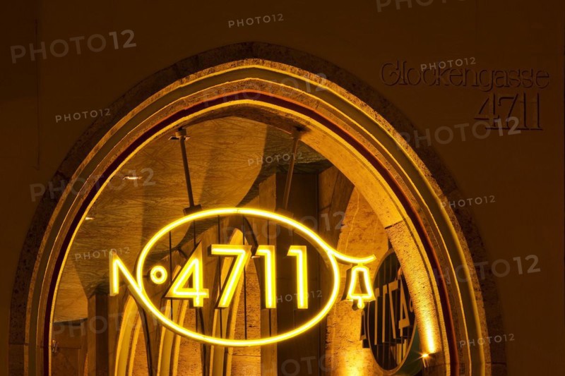Illuminated 4711 logo, new logo version from 2011 and house number on the main building in Glockengasse in the evening, Cologne, North Rhine-Westphalia, Germany, Europe