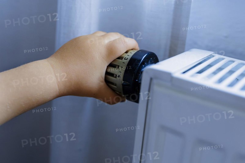 Bonn. Toddler turns the heating thermostat. Bonn, Germany, Europe