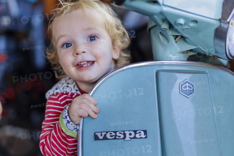 Little boy playing with a Vespa. Bonn, Germany, Europe