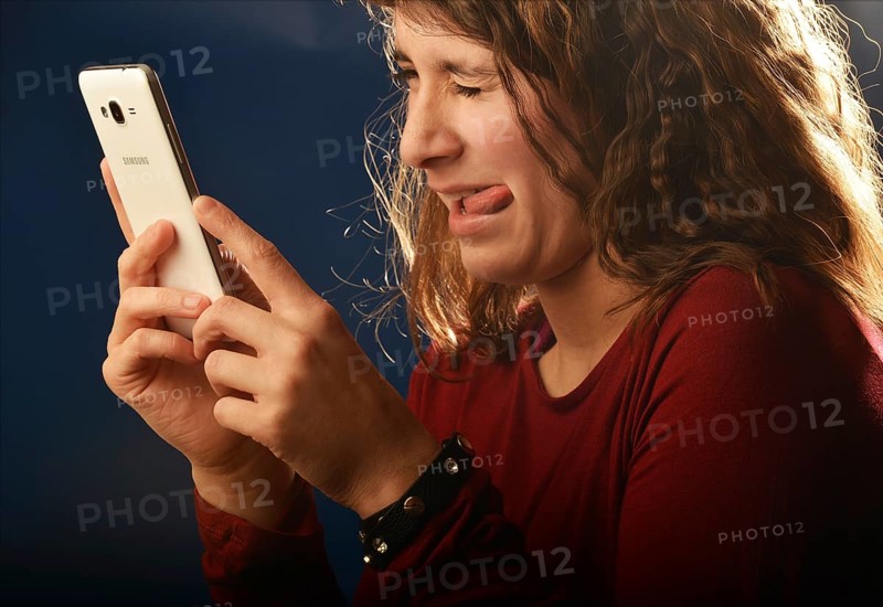 An 11-year-old girl stands as a model. With mobile phone, Germany, Europe