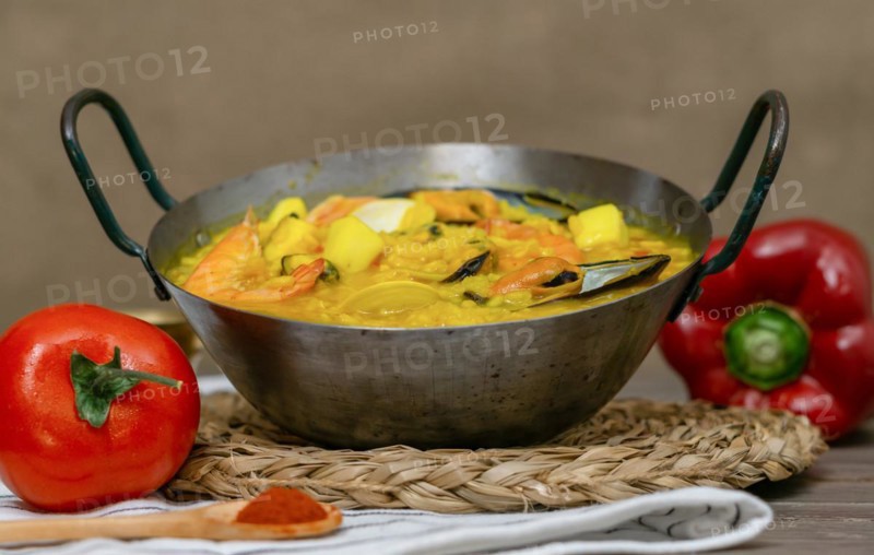 Typical spanish seafood paella in a metal casserole with all its ingredients