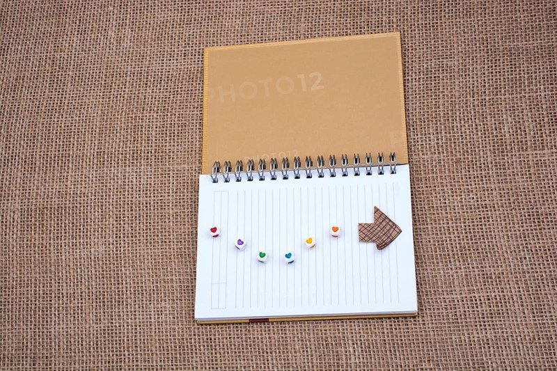 Love cubes and paper arrow on a notebook on canvas