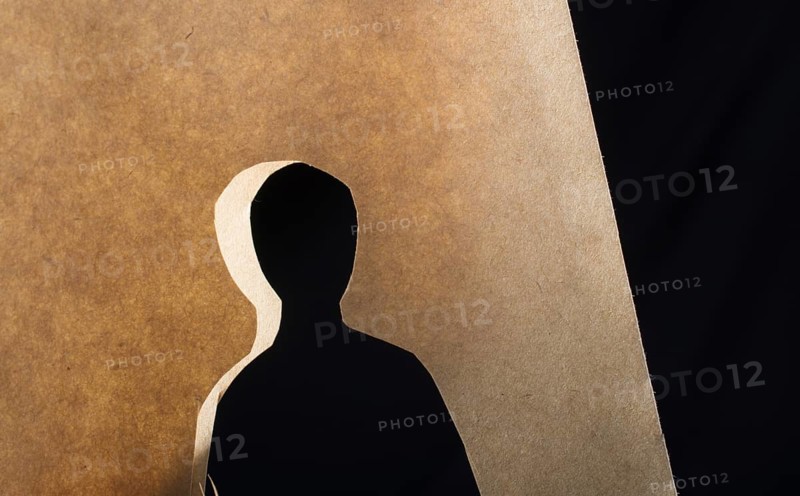 Man shape cut out of paper in hand in the view