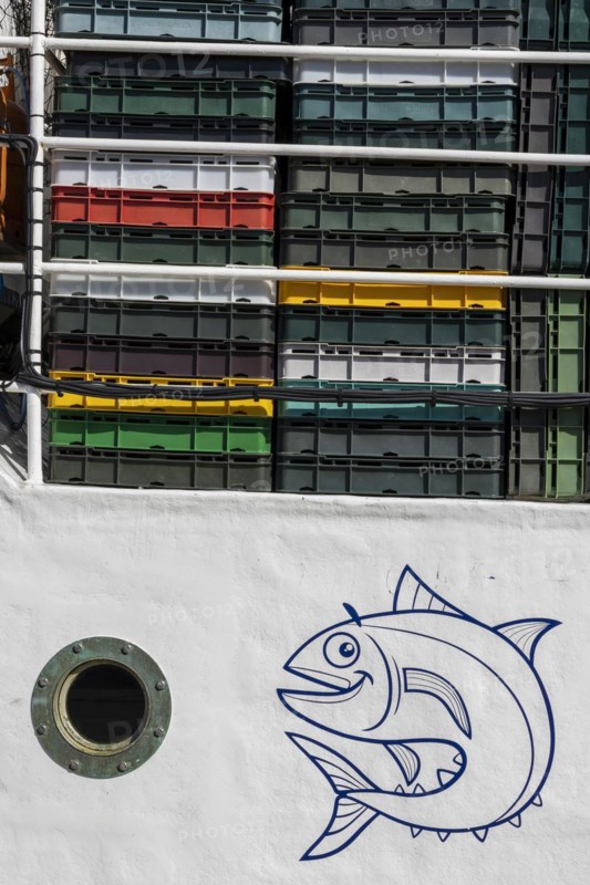 Detail of a white fishing boat with a round porthole