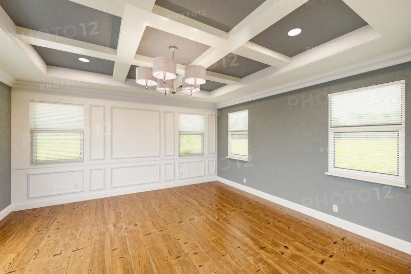 Beautiful gray custom master bedroom complete with entire wainscoting wall