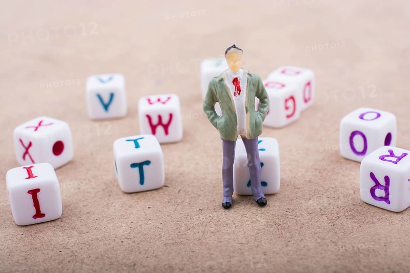Figurine standing in front of the colorful alphabet letter cubes