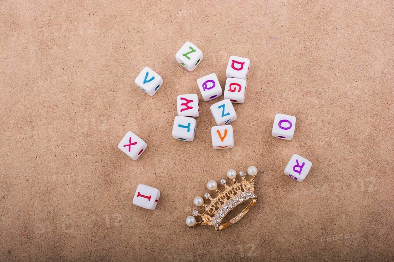 Golden color crown model in front of the letter cubes