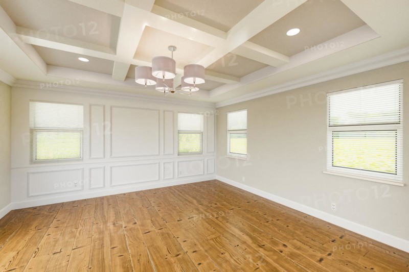 Beautiful tan custom master bedroom complete with entire wainscoting wall