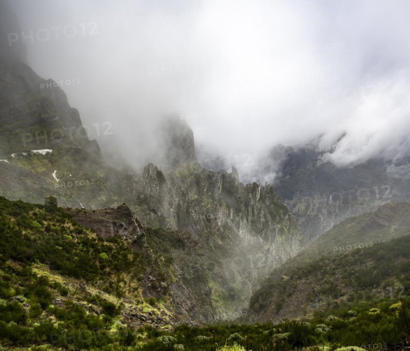 Steep cloudy mountain landscape with rock formations