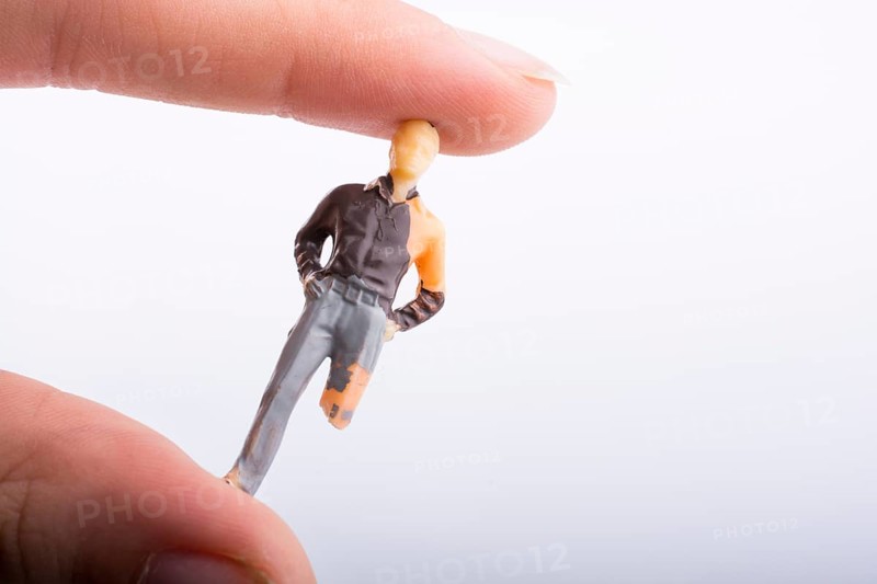 Little man figure with a crippled leg in hand on a white background