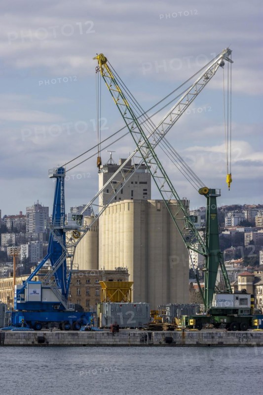 Two crossed harbour cranes on the pier and a grain silo in the middle