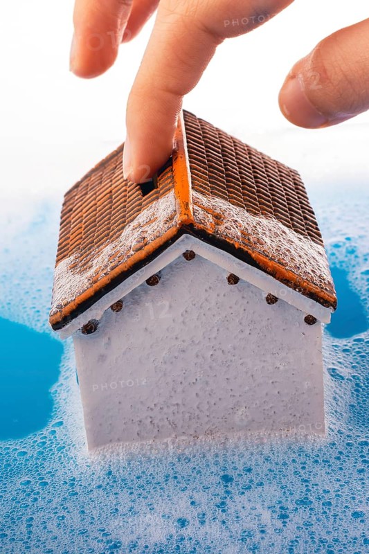 Little model house and a painting brush in foamy water