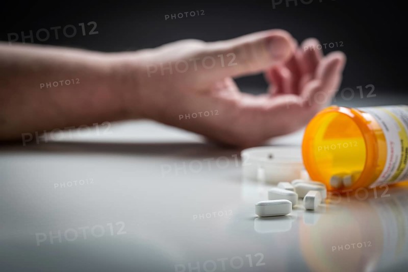Man passed out on floor behind scattered drugs and medicine bottle
