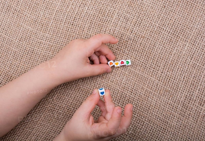 Little cubes with heart shape in hand on canvas