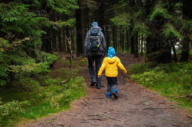 Mum and her little son go on a mountain trail in wet autumn weather. Polish mountains