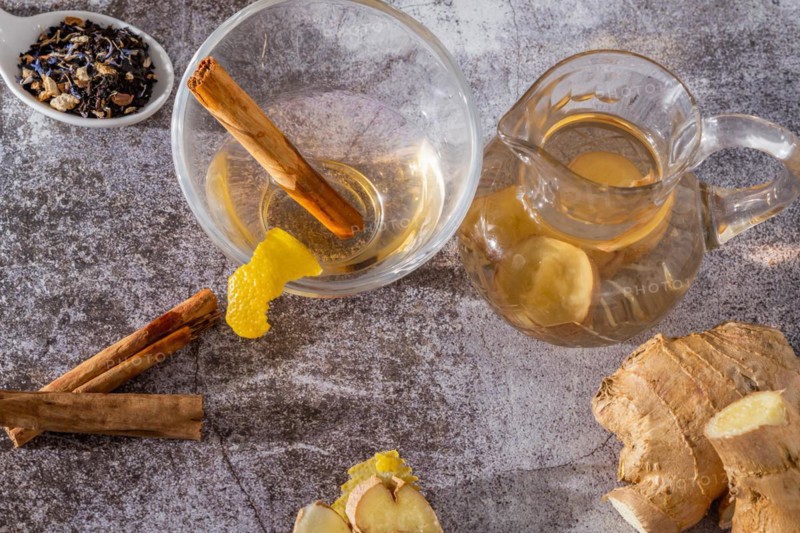 Top view of jar of fresh ginger tea with lemon and cinnamon