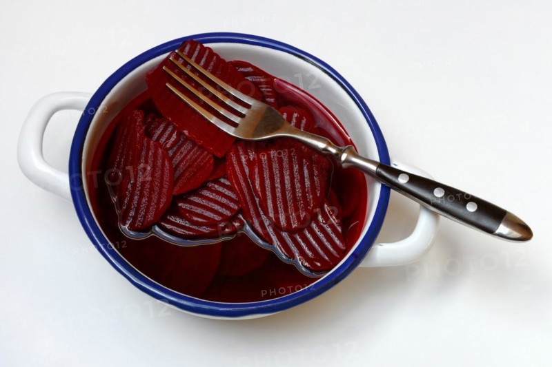 Sliced pickled beetroot with peel and fork