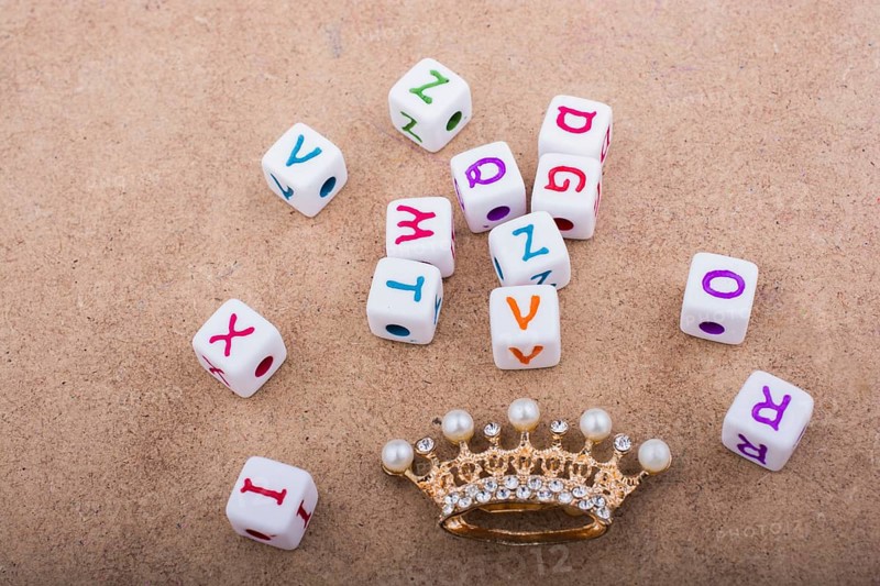 Golden color crown model in front of the letter cubes