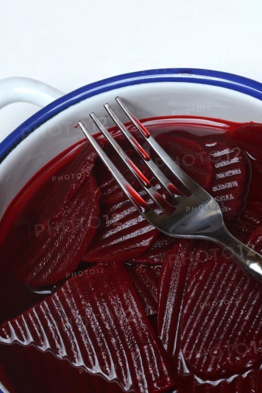 Sliced pickled beetroot with peel and fork