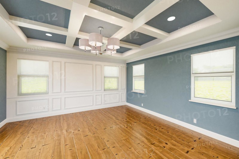 Beautiful blue-gray custom master bedroom complete with entire wainscoting wall