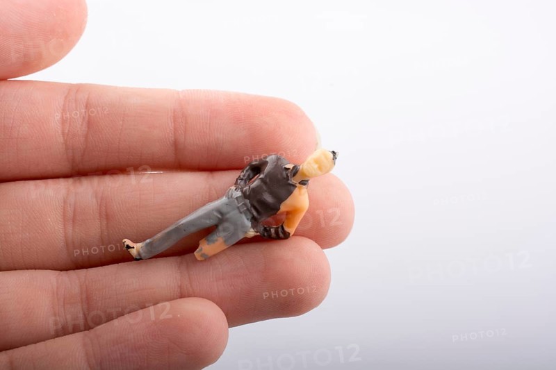 Little man figure with a crippled leg in hand on a white background
