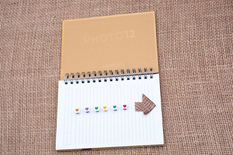 Love cubes and paper arrow on a notebook on canvas