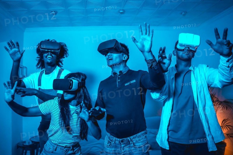 Group of young people in vr glasses in a virtual reality game in a blue light