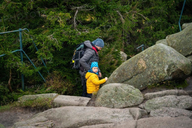 Mum and her little son go on a mountain trail in wet autumn weather. Polish mountains