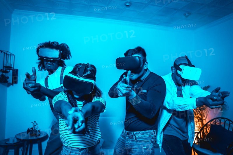 Group of young people with vr glasses in a virtual reality game in a blue light