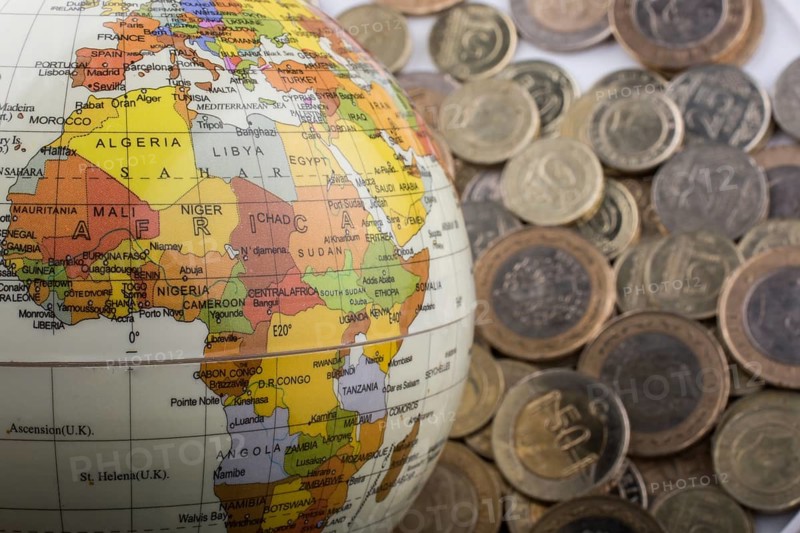 Turkish Lira coins by the side of a model globe on white background