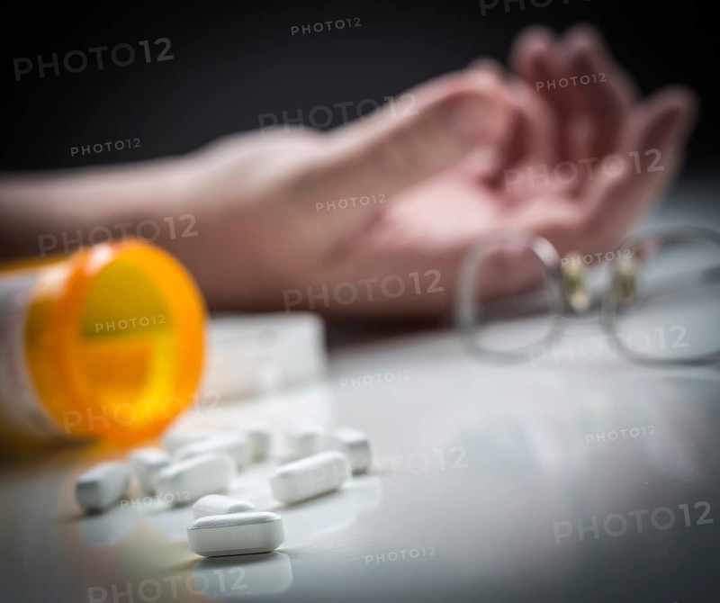 Man passed out on floor behind scattered drugs and medicine bottle