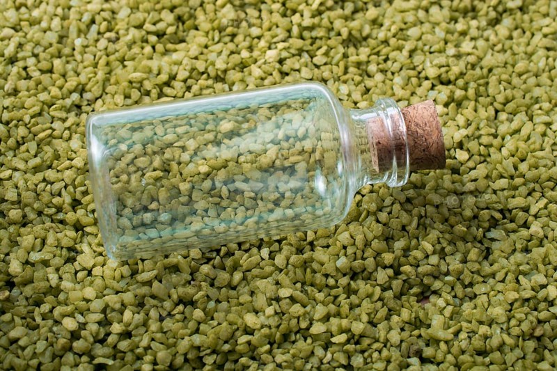 Empty little bottle is placed on green sand
