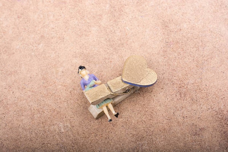 Woman figurine trapped in a clothespin on ground