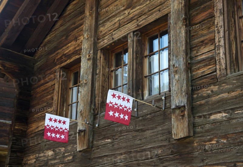 Two flags of the Canton of Valais in the window of a Swiss chalet