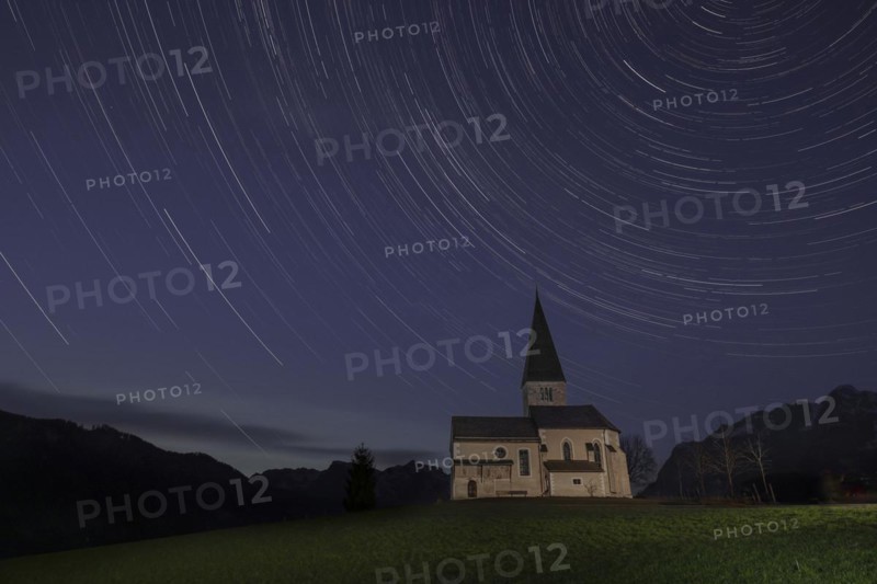 Church on a mountain with star trails in Pongau