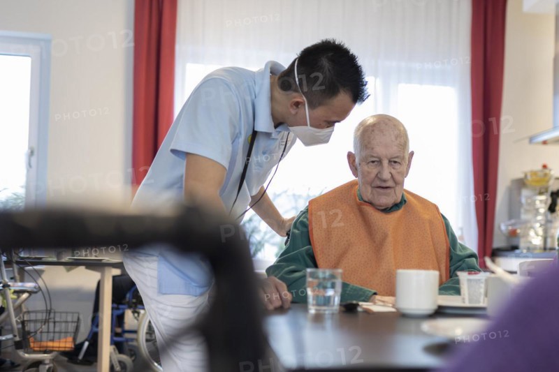 Carer talking to a man in a nursing home