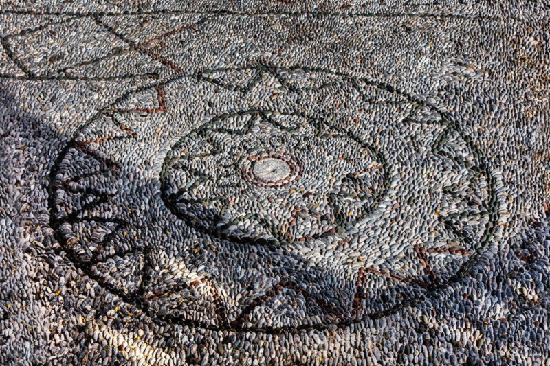 Pebble mosaic in front of the cross-domed church of Kimissis tis Theotokou