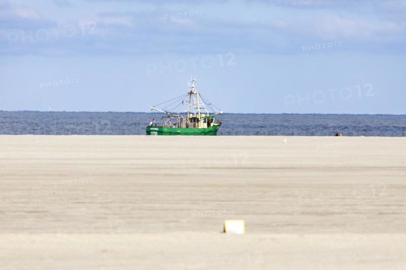 Crab cutter on the North Sea coast and sandy beach at low tide