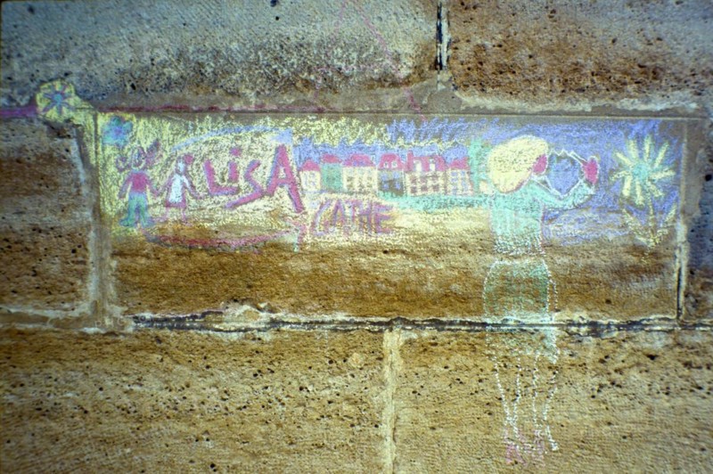 Faded chalk drawing on a house wall