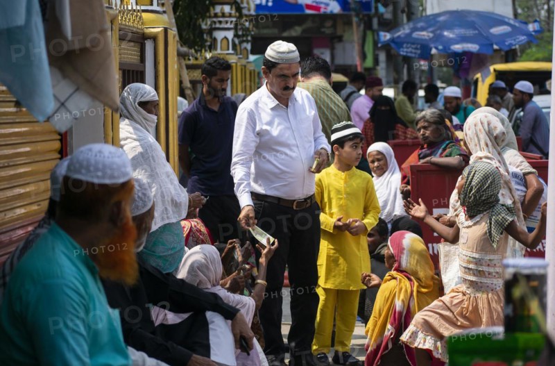 Indian Muslims person give money to needy people after perform the second Friday prayer in the holy month of Ramadan at a Mosque in Guwahati
