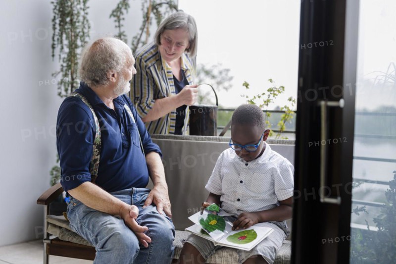 Temporary grandparents. Grandfather volunteers to look after a boy from Africa for a few hours a week.