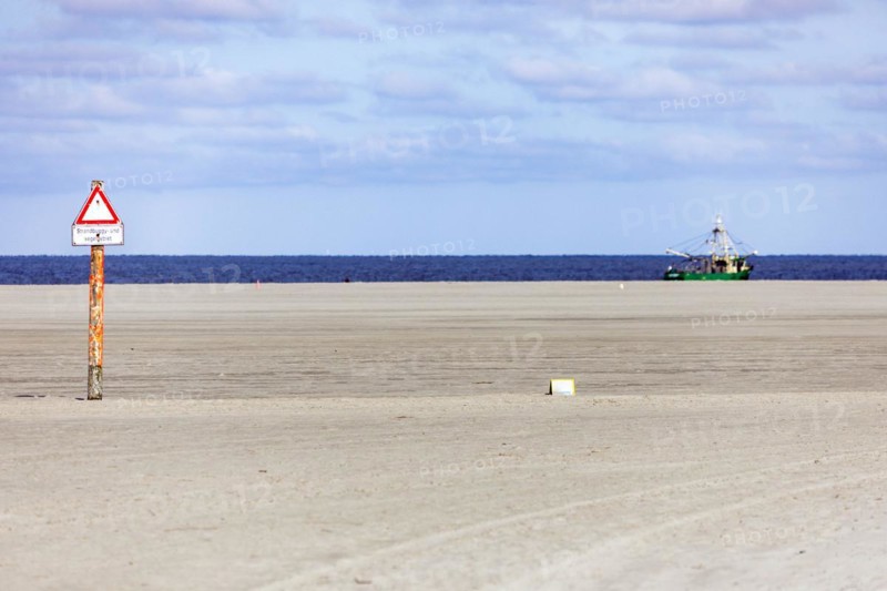 Crab cutter on the North Sea coast and sandy beach at low tide