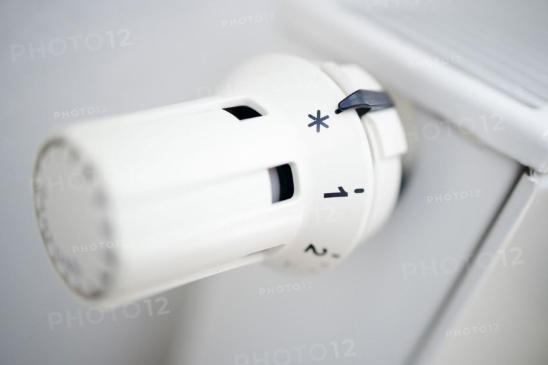 Symbol photo on the subject of increased heating costs. The thermostat of a heating system is set to the symbol snowflake