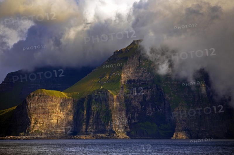 The Faroe Island of Kalsoy in the Atlantic Ocean with Sun and Clouds