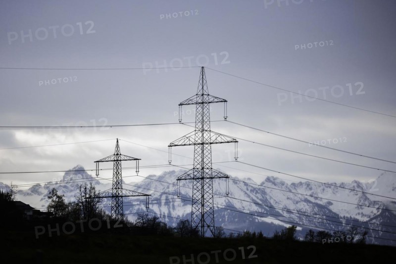 High-voltage masters stand on a hill against the backdrop of the Austrian Alps. Widnau