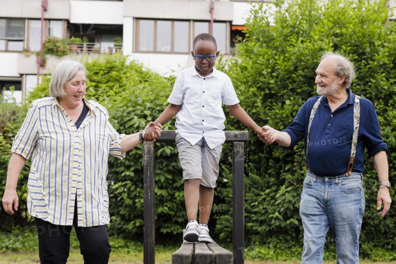 Grandparents on time. Grandparents with a boy on a playground.